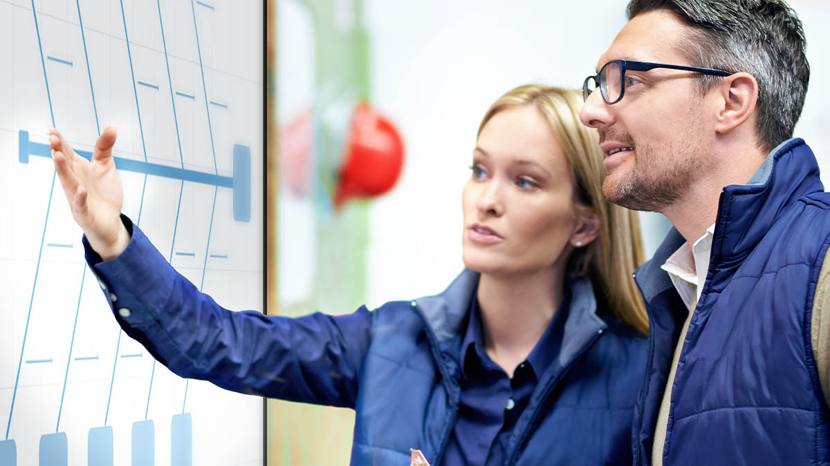 Corporate team members analyzing data on a SMART Board interactive display in an industrial setting.