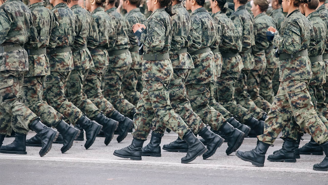 Military personnel in uniform performing a coordinated march.