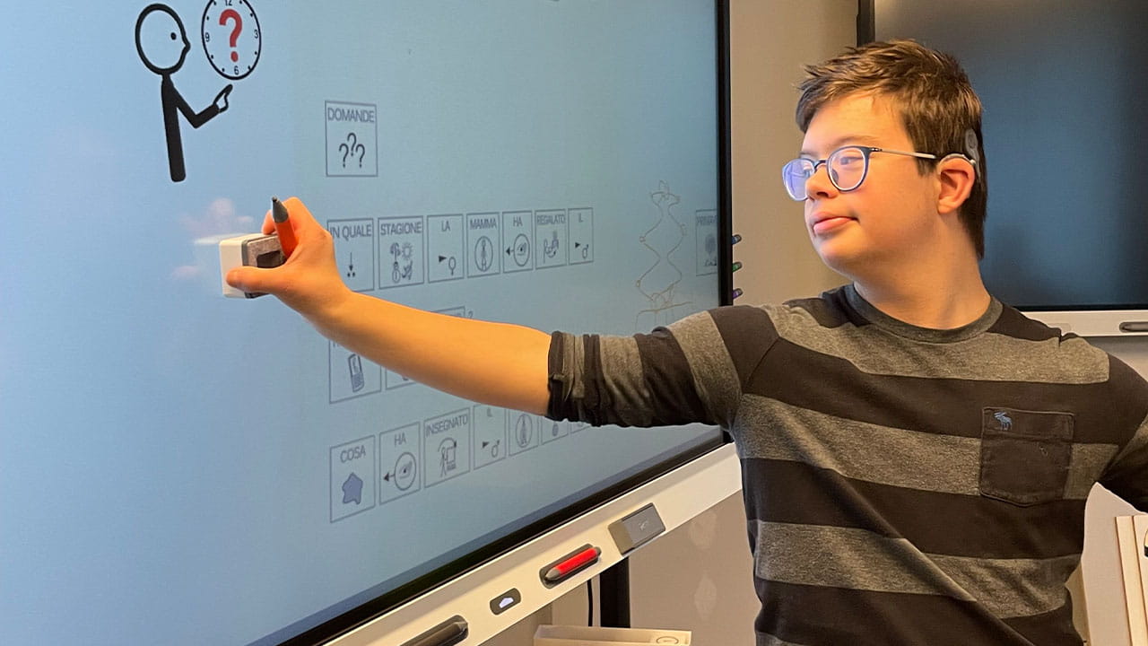 Student engaging with an interactive SMART Board as part of an inclusive learning environment.