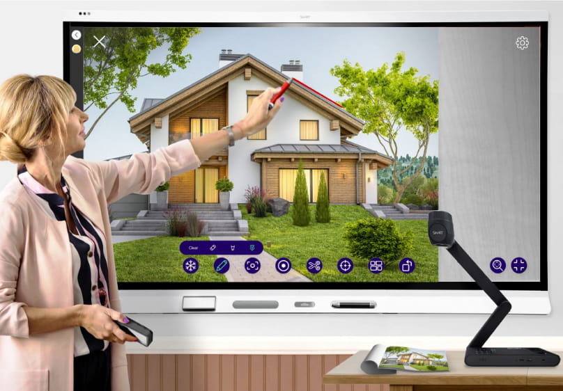 Educator using a SMART Document Camera to interact with 3D house modeling on a SMART interactive display.