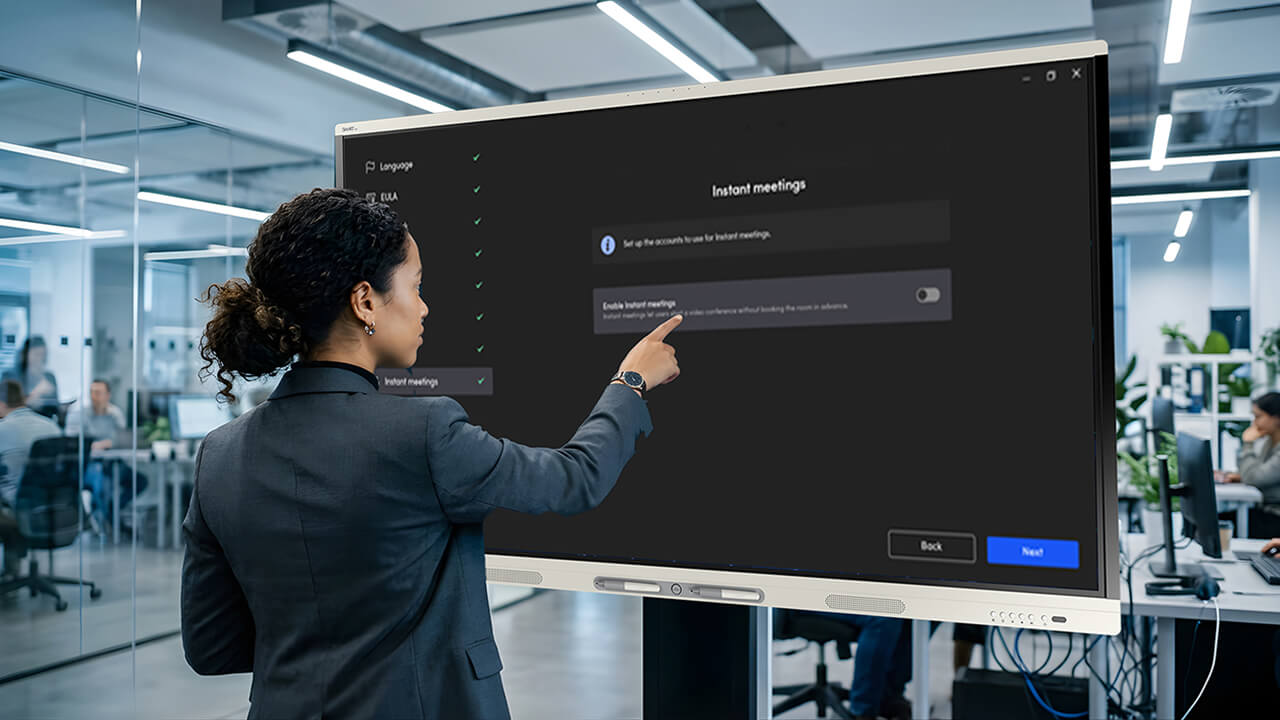 User configuring SMART TeamWorks meeting settings on an interactive display in a modern office environment.