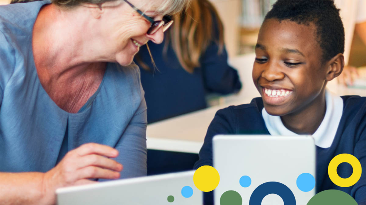 Teacher and young student smiling while working on a laptop, with colorful abstract design elements in the background.