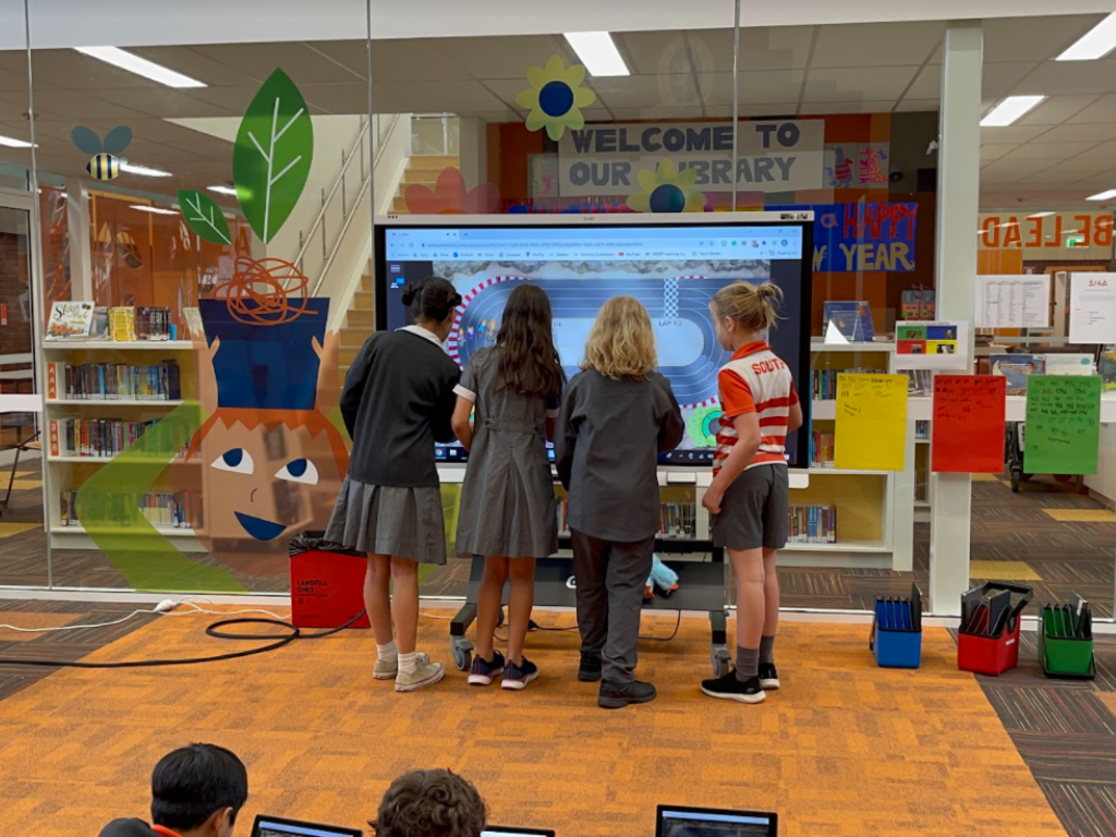 A group of students working collaboratively on an interactive display.