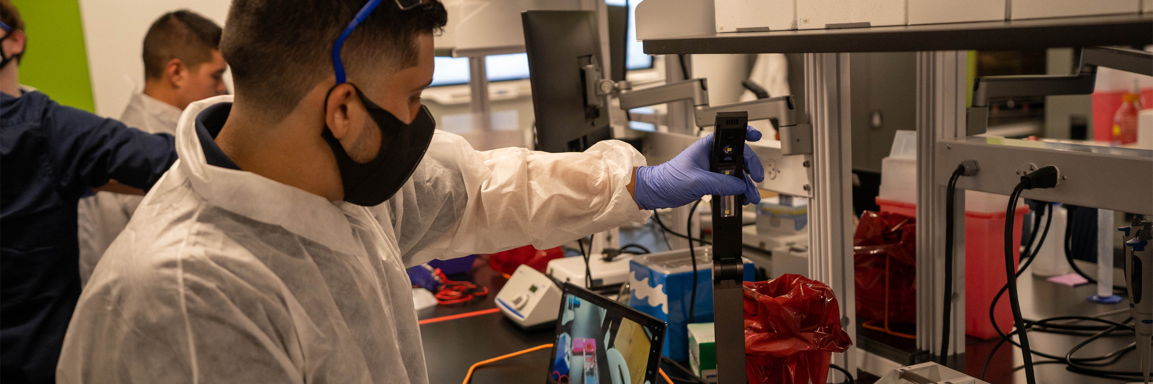 High school student experimenting with a machine.