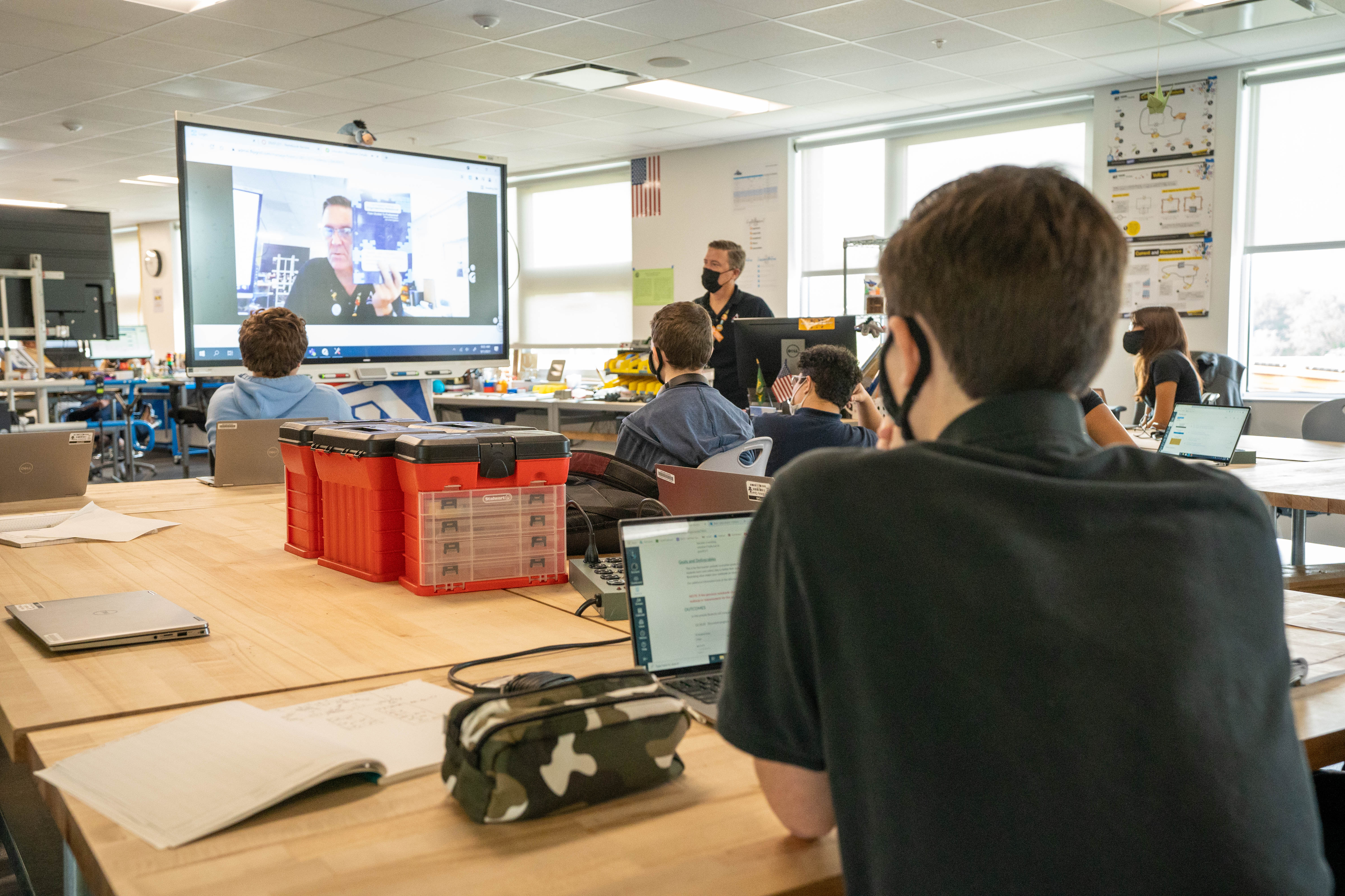 A student watches an interactive lesson on his teacher's SMART display. 