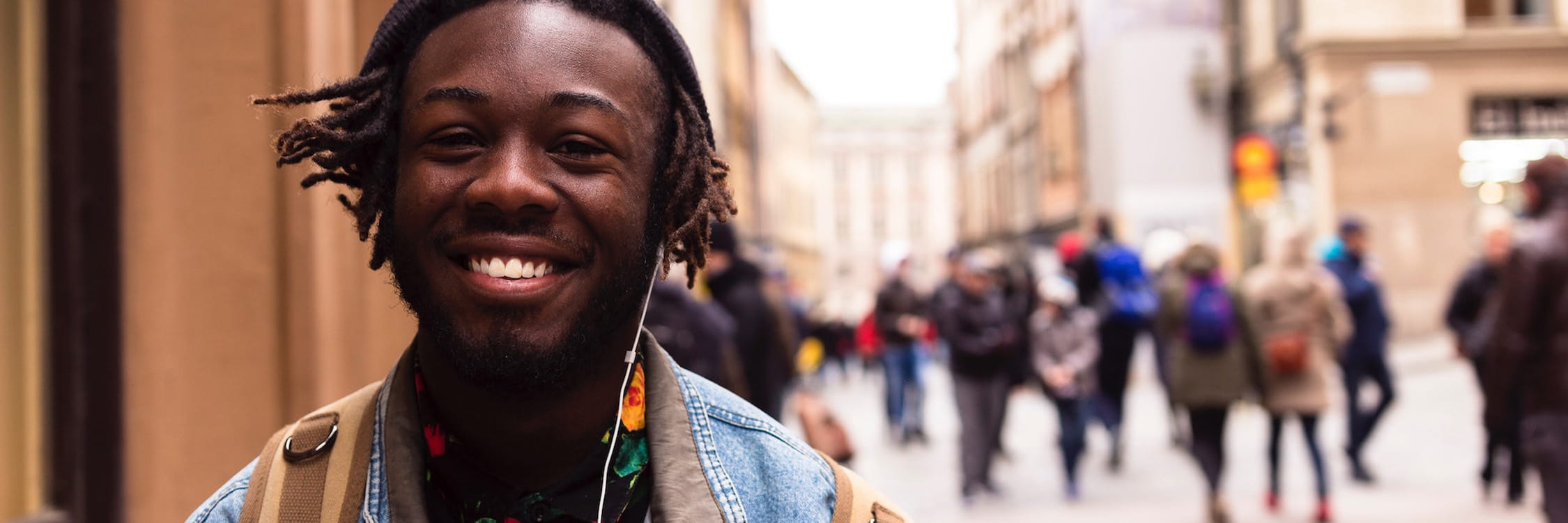 Mature student smiling in a busy street.