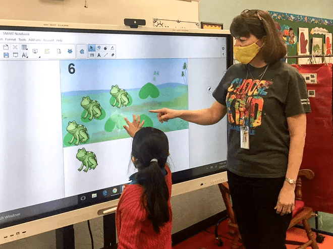 A student and teacher collaborate at a SMART board in the Palm Beach School district. 