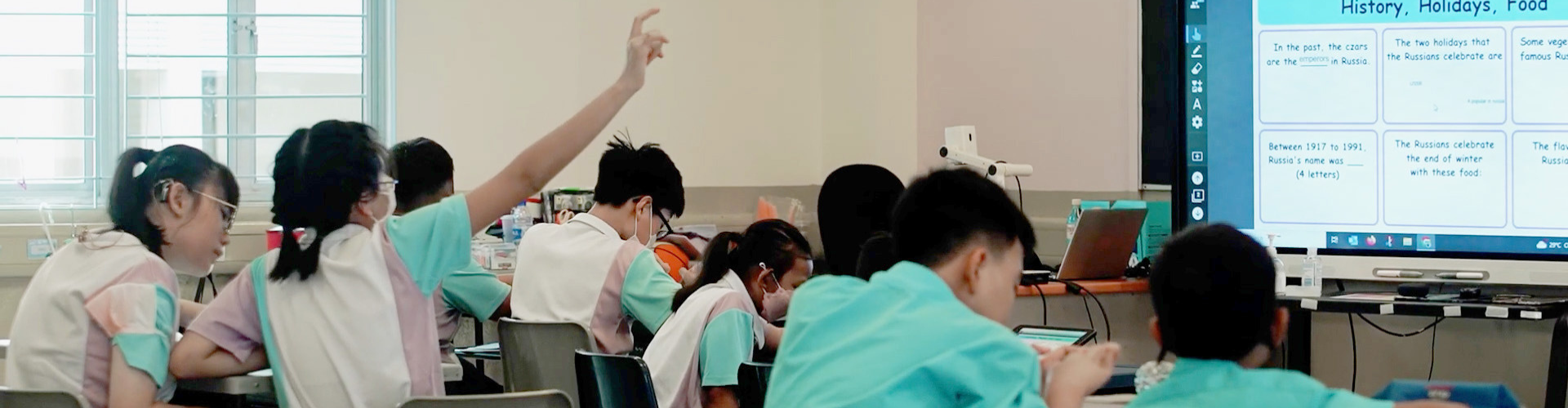 A classroom full of students working collaboratively in small breakout groups.