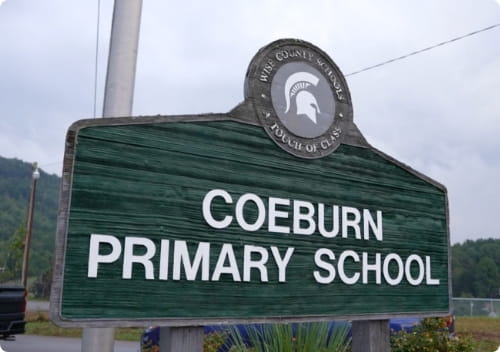 Coeburn Primary School sign with a spartan emblem.