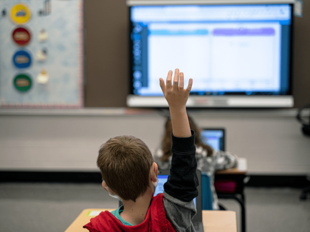 Student raising hand in classroom