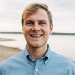 Portrait of Stanton Terrell smiling outdoors, wearing a light blue button-up shirt.