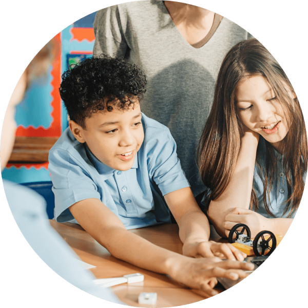 Two students actively engaging with hands-on educational tools in a classroom setting, reflecting collaborative learning.